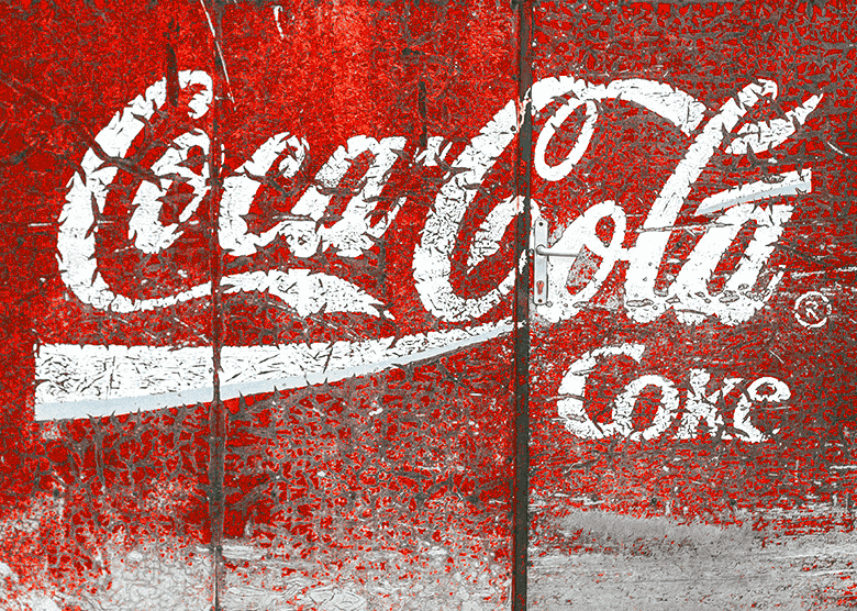 słynne ponadczasowe logo marki Coca-Cola na starym budynku jako ilustracja cech dobrego logo